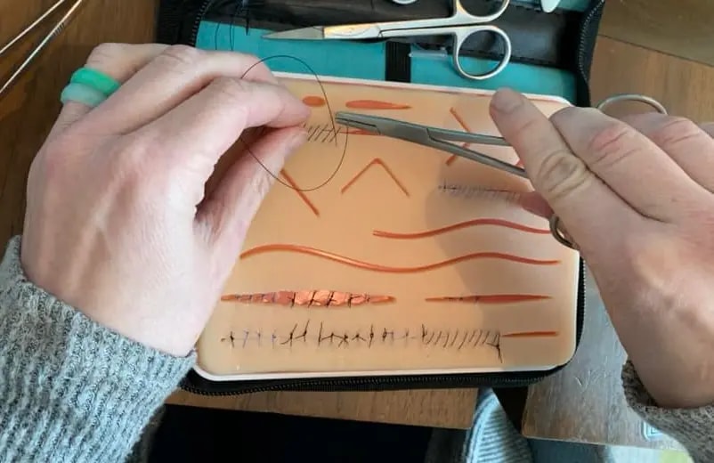 students suturing with a plus medics suture practice kit
